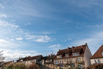 Fototapeta na wymiar blue cloudy sky over three storey houses 