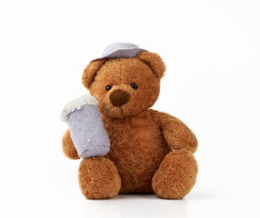 cute little brown teddy bear holds a felt mug with foam and is dressed in a gray hat
