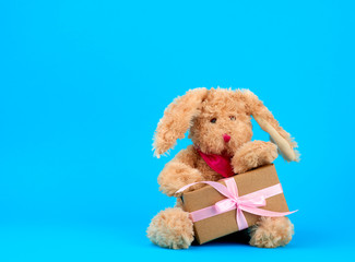 cute little brown plush rabbit  and box wrapped in brown kraft paper and tied with pink silk ribbon
