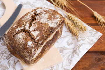 homemade rustic rye bread, gourmet bread for a restaurant, lies on a wooden table