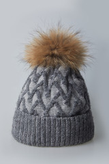 Warm winter gray hat with fur on a white background