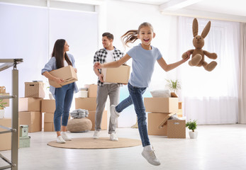 Fototapeta premium Happy family in room with cardboard boxes on moving day