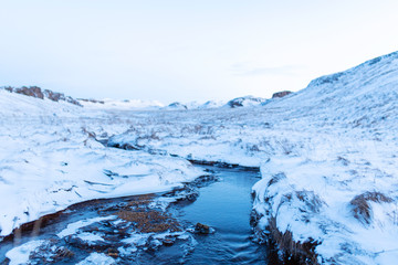 Incredible winter landscape of Iceland. In winter, a source of hot water flows in the mountains