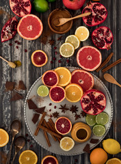 Obraz na płótnie Canvas Flat lay abstract collage of various citrus fruits along with cinnamon, honey, chocolate and pomegranates.