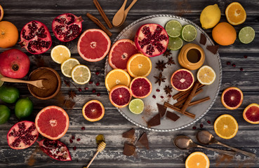 A flat lay arrangement of various citrus fruits complimented with honey, chocolate and cinnamon.