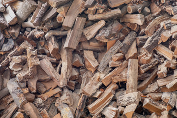 Chopped firewood on a stack. Background of dry chopped firewood logs in a pile. Texture, wallpaper.