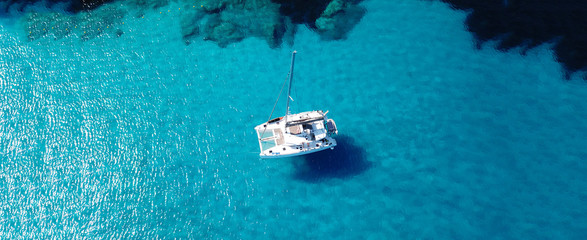 Aerial drone ultra wide photo of sailing yacht anchored in paradise turquoise sea exotic island...