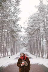 Fototapeta na wymiar Woman drinking coffee in winter snow forest.