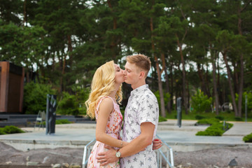 Loving young couple kisses in green park