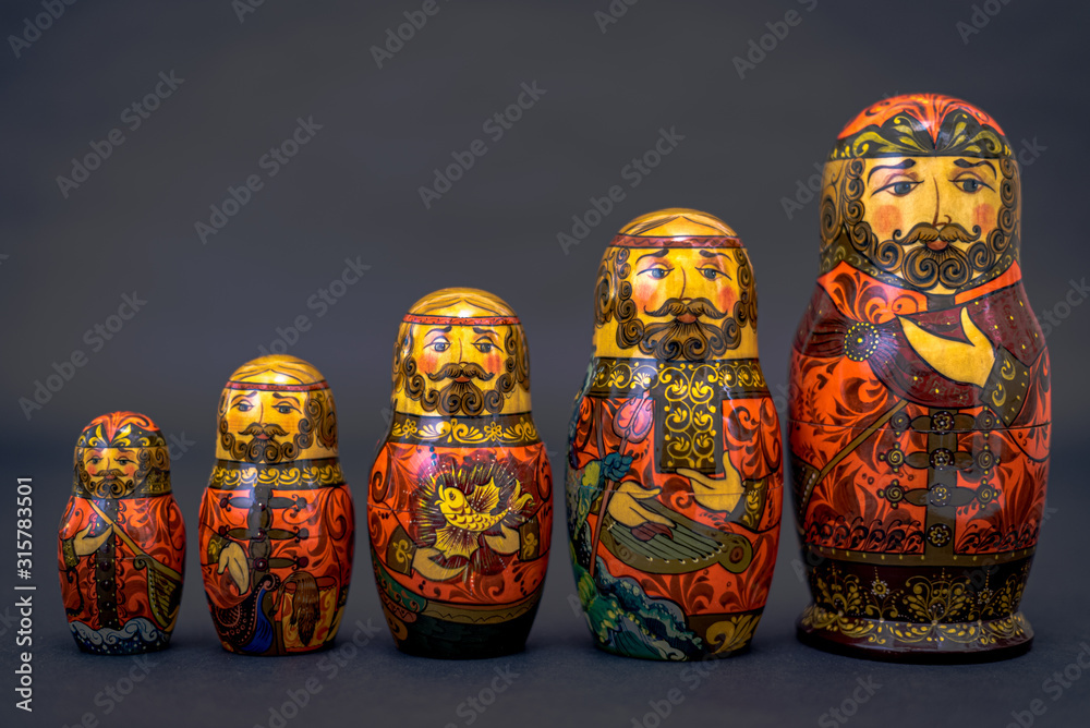 Wall mural Traditional Russian matryoshka dolls lined up against gray background, doll within a doll, object within an object, metaphor for shell companies, Russian nesting doll 7