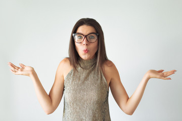 Young girl with long brown hair holds imaginary copyspace on her palm laughing. She is dressed up in white t-shirt.