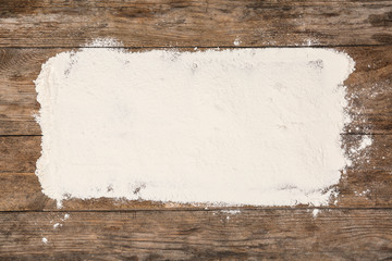 Pile of flour on wooden table, top view