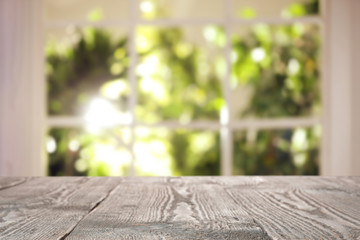 Empty wooden table in front of window. Sunny morning