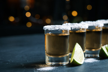 Mexican Tequila shots, lime slices and salt on bar counter