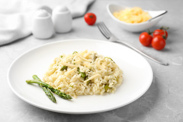 Delicious risotto with asparagus on grey marble table
