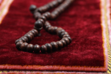 Close up shoot of a Praying beads on a sajadah (Carpet for moslem praying)