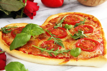 pizza Heart shaped margherita with tomatoes and mozzarella vegetarian. Food concept of romantic love pizza for Valentines Day.