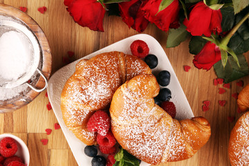 Delicious breakfast with fresh croissants and ripe berries and mint for valentines day