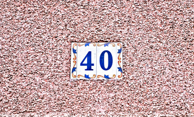 Elegant number 40, forty, decorative tile centered on clean bright pale pink background.