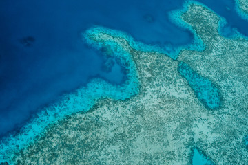 Birds eye view shot of deep blue water and coral reef
