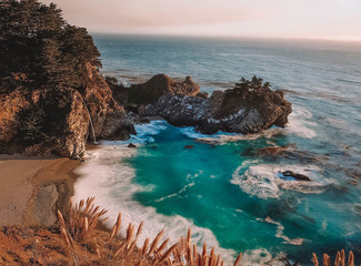 Small gulf of deep blue water, waves crashing into cliffside