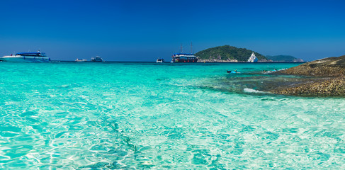 Sunny day with blue sky and turquoise water at tropical beach and sailboat on the horizon, Similan Islands, Thailand