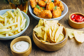 Table fof tasty snacks and beer prepared for watching sports on TV. Selective focus
