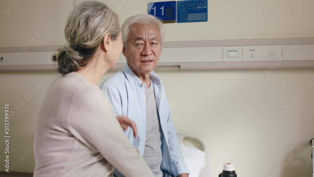 Wall mural asian old couple talking chatting in hospital ward