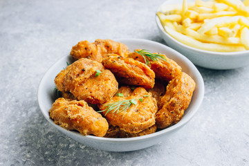 Fried crispy chicken nuggets with french fries and ketchup on light gray background. Seletive focus