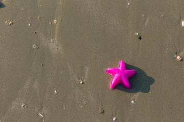 Plastic star toy scrap on the beach