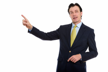 Studio shot of mature handsome businessman pointing finger