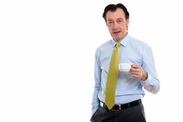 Studio shot of mature handsome businessman holding coffee cup