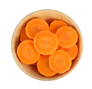 Peeled carrots, sliced into pieces in a wooden bowl isolated on white background, Top view.