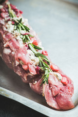 Raw pork loin with fruits, blue cheese and rosemary ready for baking. Selective focus. Shallow depth of field.
