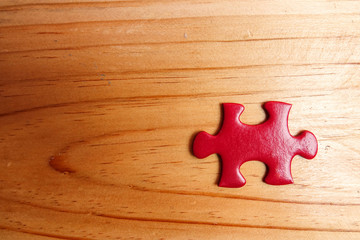 Missing red jigsaw puzzle on wooden table. Copy Space