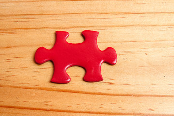 Missing red jigsaw puzzle on wooden table. Copy Space