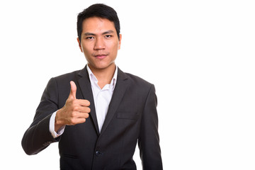 Studio shot of young Asian businessman giving thumb up