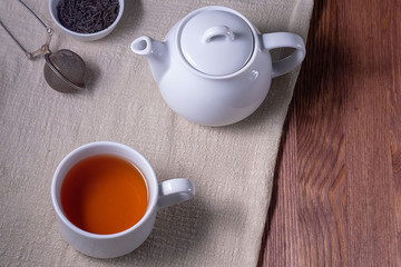 Tea. Cup of tea and teapot on a dark wooden table. Top view, copyspace
