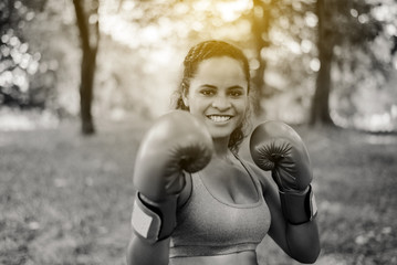 Sporty black woman boxer punching to you at park,Female boxer eye looking training to camera,Happy...