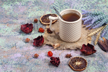 Red Hot Hibiscus tea in a glass mug on a wooden table among rose petals and dry tea custard with carcade