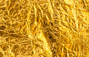 Gold crumpled foil paper texture background.