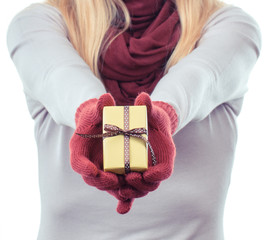 hand of woman holding wrapped gift for valentine or other celebration
