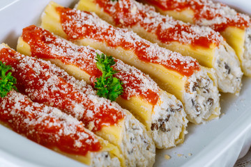 Cannelloni pasta staffed with ricotta, parmesan and mushrooms. Close up.
