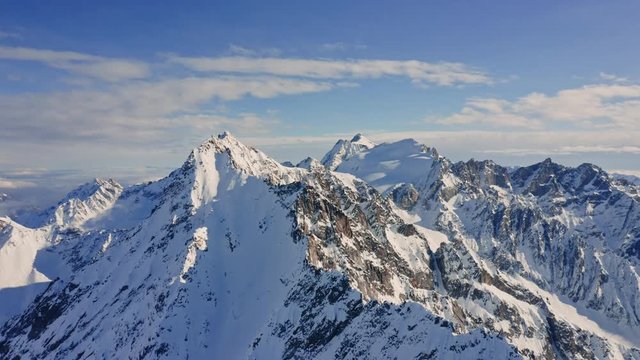 Aerial Drone View of the Italian Alps in Wintertime.
Flying over the Snowy Mountains during Sunny Day with Clear Blue Sky.
