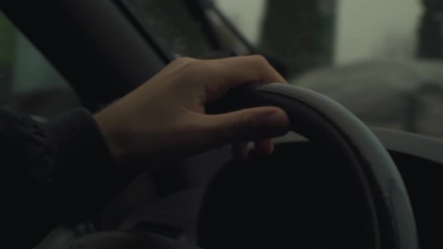 A Man Driving A Car One-Handed Moving The Steering Wheel From Right To Left  Direction - Close Up Shot