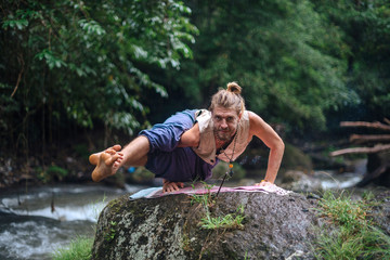 Naklejka na ściany i meble Yoga practice and meditation in nature. Man practicing near river