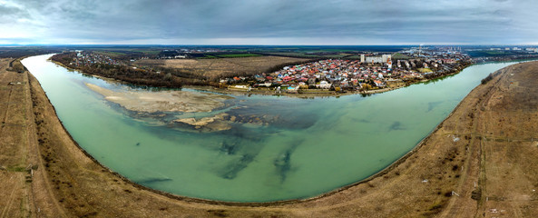 aireal drone view panorama of the Adyghe bank of the Kuban River and Starobrzhegokai aul near the western edge of the city of Krasnodar in southern Russia - on a cloudy January day of snowless winter