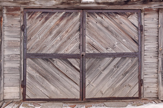 old wooden gate to the barn, board structure, wood texture, rusty metal lock