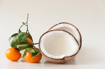 mixed fruit: coconut, fresh apples and mandarins with green leafs.
