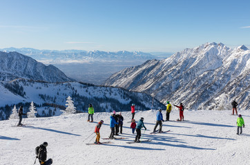 Skiers and snowboarders on top of Hidden Peak ready to ski down at Snowbird Ski Resort in Little Cottonwood Canyon in the Wasatch Range near Salt Lake City, Utah, USA.